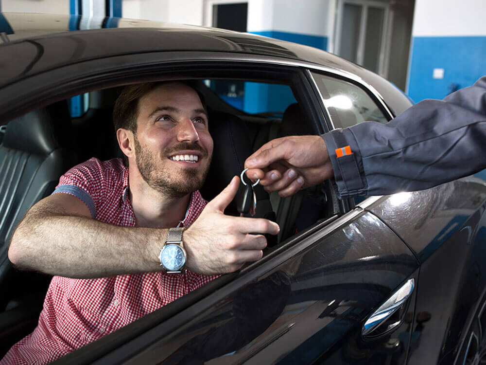 Happy customer receives car keys from mechanic